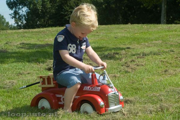 De loopauto heeft metalen wielen met rubberen banden.